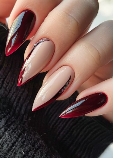 Elegant burgundy nail art featuring almond-shaped designs and striking glitter accents.