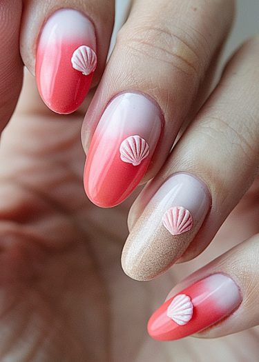 Elegant coral ombre nails with seashell accents for a stylish beach-inspired manicure.