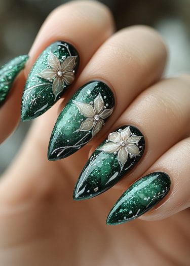 Elegant emerald nails featuring intricate floral designs and shimmering details for luxurious nail art.