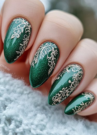 Elegant emerald green nails with gold floral designs for a sophisticated manicure look.