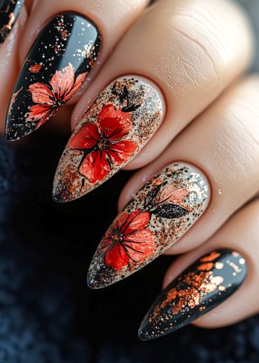 Elegant stiletto nails featuring vibrant floral designs and glittery accents against a glossy black background.