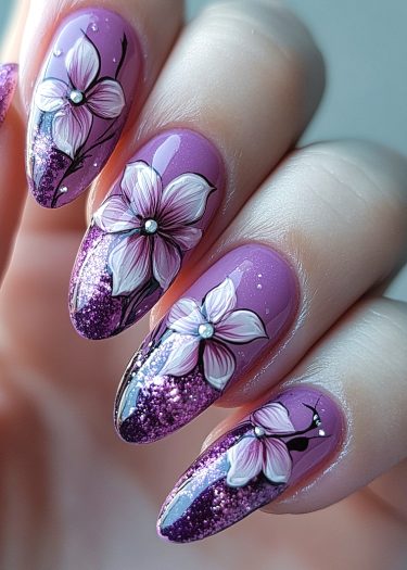 Elegant purple floral nail art with glitter and rhinestones for a sophisticated look.