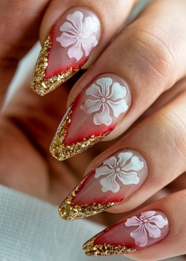 Elegant floral nail art with pink and red gradient, gold glitter tips, and intricate designs.