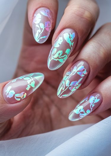 Elegant floral nail art with holographic designs on almond-shaped nails in soft pink.