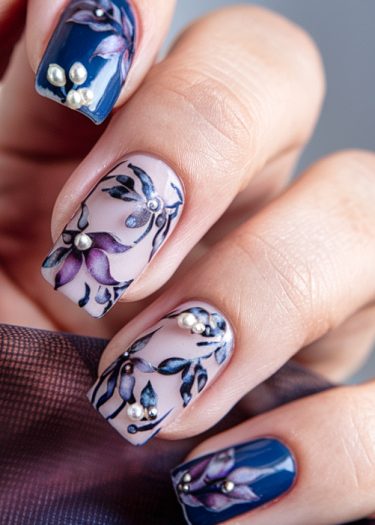 Elegant floral nail art featuring blue and pink designs with pearls for a sophisticated look.