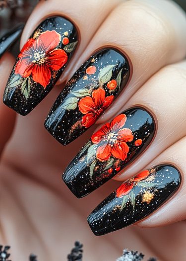 Elegant floral nail art in glossy black with red flowers and shimmering golden accents.