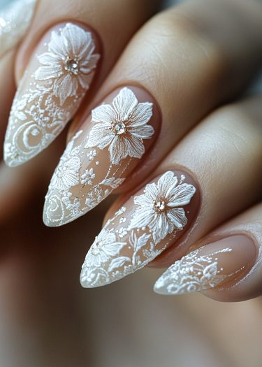 Elegant stiletto nails with intricate floral designs and rhinestones for a stunning nail art look.