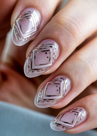 Elegant geometric nail art design featuring pink almond-shaped nails and metallic silver details.