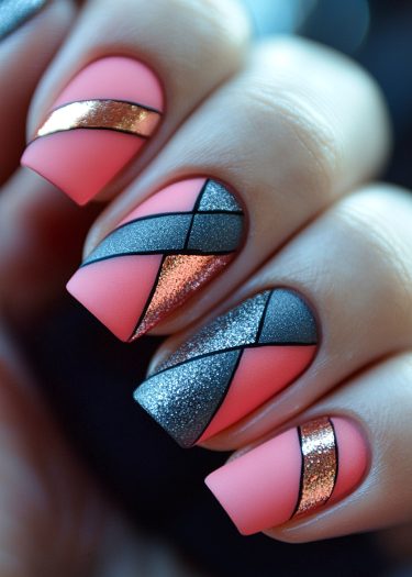 Elegant geometric nail art design in coral pink with metallic accents and intricate patterns.