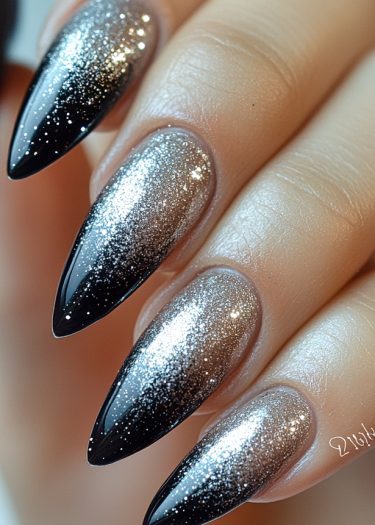 Stunning ombre stiletto nails featuring silver glitter and black tips for elegant nail art.