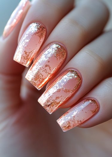 Elegant gold foil over nude nails for a sophisticated and glamorous nail art look.