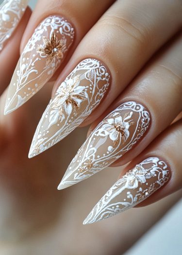 Exquisite stiletto nail art with gold floral designs and lace details for elegant style.