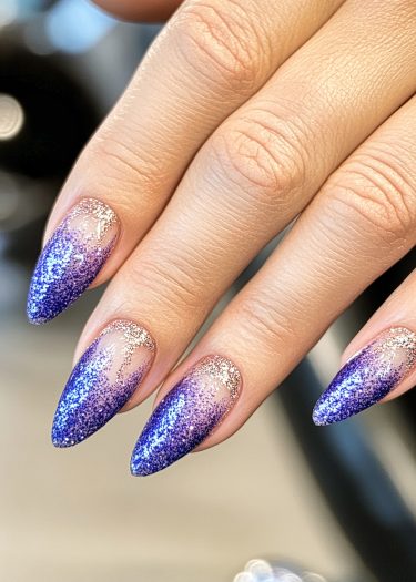 Elegant stiletto nails feature a vibrant blue to purple glitter gradient for a sophisticated look.