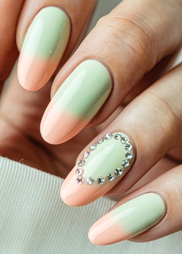 Elegant almond-shaped nails with a mint-peach gradient and rhinestones for a sophisticated look.