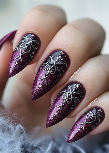 Elegant almond-shaped nails in deep plum with shimmering glitter and intricate silver designs.