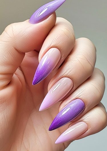 Elegant stiletto nails with a stunning gradient from light pink to deep lavender.