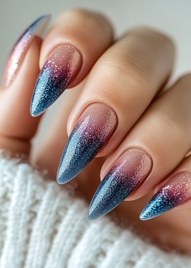 Elegant almond-shaped gradient nails with blue and pink ombre, showcased on a cozy white fabric.