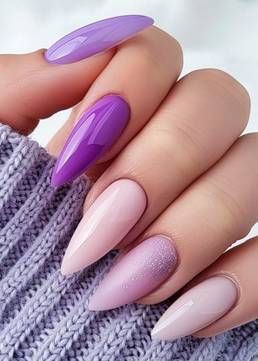 Elegant stiletto nails in purple and pink gradients with sparkles, paired with a cozy lavender sweater.