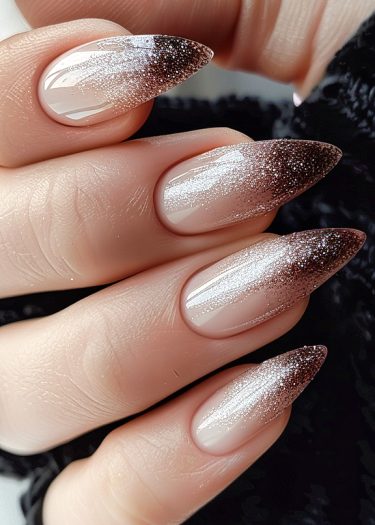 Elegant almond-shaped nails with a dazzling brown gradient and glittery tips.