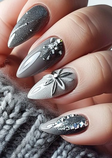 Elegant gray almond-shaped nails with glossy finish and unique embellishments for a sophisticated look.