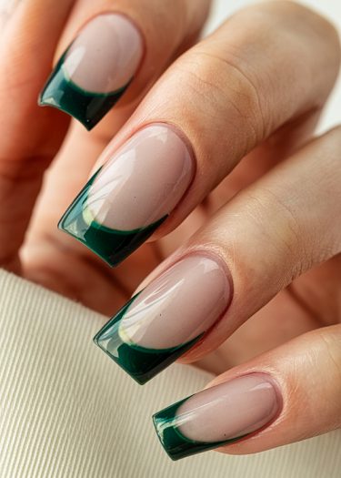 Elegant green French tips on nude nails showcase modern nail art and sophisticated design.