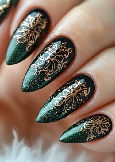 Elegant stiletto nails with deep green polish and intricate gold lace designs.