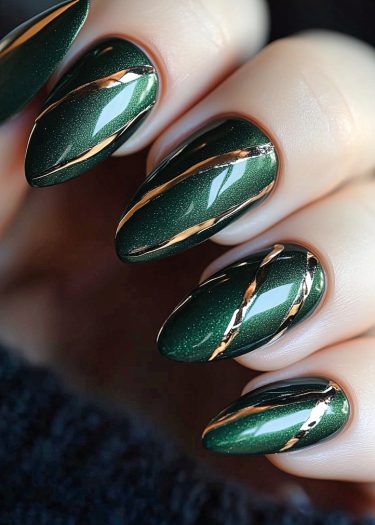 Elegant green manicure with gold stripes, showcasing chic almond-shaped nails and glossy finish.