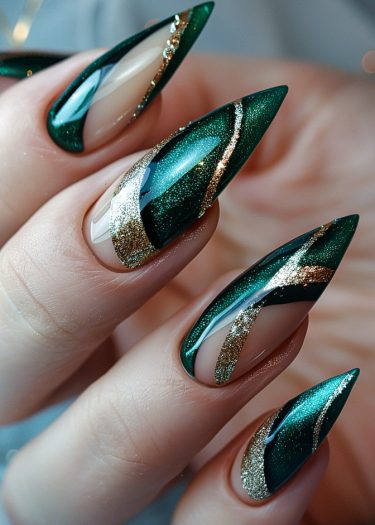 Stunning emerald green and gold stiletto nails showcasing elegant manicure artistry and glamour.