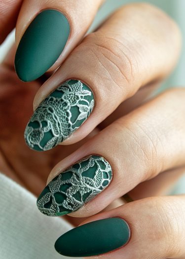 Elegant deep green matte nail art with intricate lace design for a sophisticated look.