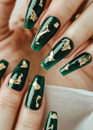 Elegant green nail art with gold foil accents for a luxurious and sophisticated look.