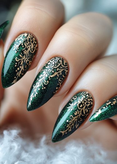 Elegant emerald green nail art with gold filigree design for a luxurious manicure.