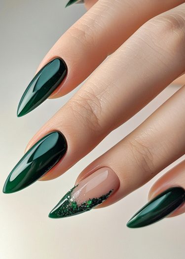 Elegant green almond-shaped nails with unique ring finger design showcasing luxurious nail art.