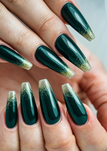 Elegant dark green stiletto nails with gold glitter for a sophisticated manicure.