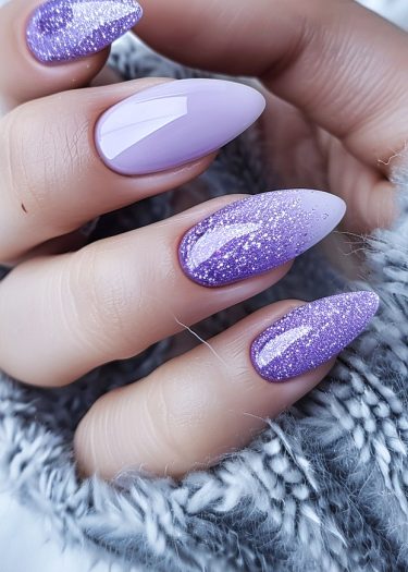 Elegant lavender nail art featuring a gradient of glossy and glittery finishes on almond-shaped nails.