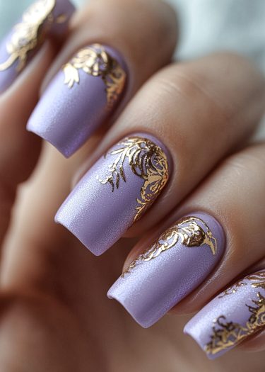 Elegant lavender nails with intricate gold designs, perfect for chic and sophisticated looks.