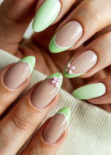 Elegant almond-shaped nails with lime green tips and floral accents for a chic manicure.