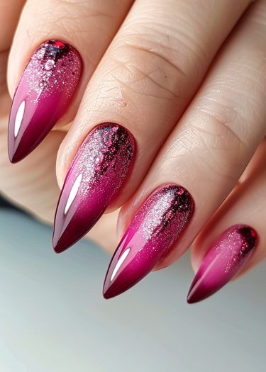 Elegant magenta nails with ombre gradient and glitter, showcasing sophisticated nail art design.