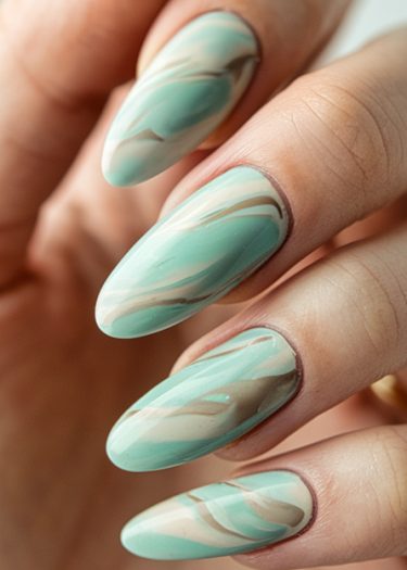 Elegant almond-shaped nails with intricate mint green and cream marble design.