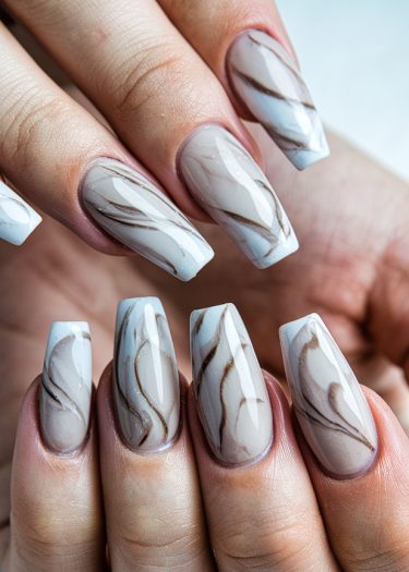 Elegant coffin-shaped marble nail art in soft grays and beiges for a chic look.