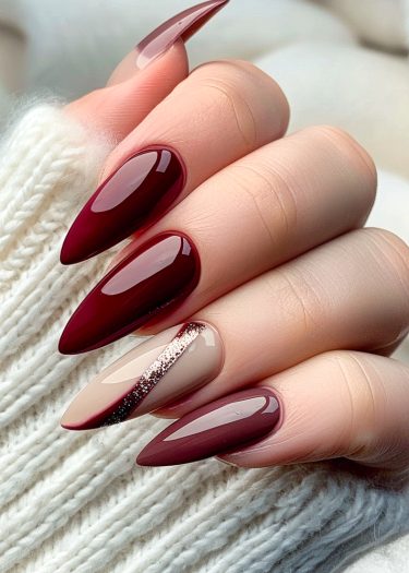 Stunning maroon manicure with elegant beige accents on a cozy textured background.