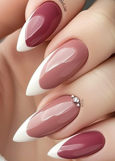 Elegant maroon and pink almond-shaped nails with white tips and rhinestones for a chic look.