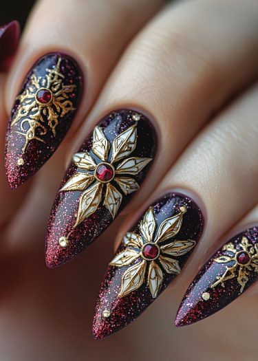 Elegant burgundy stiletto nails featuring intricate gold designs and red gemstones for luxury.