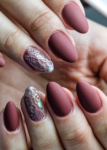 Elegant almond-shaped matte mauve nails with iridescent lace accents for sophisticated nail art.