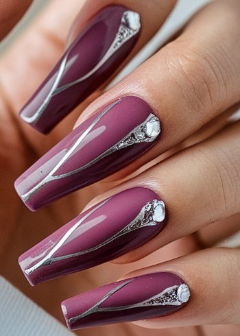 Elegant mauve stiletto nails with silver accents and rhinestones for a sophisticated nail design.