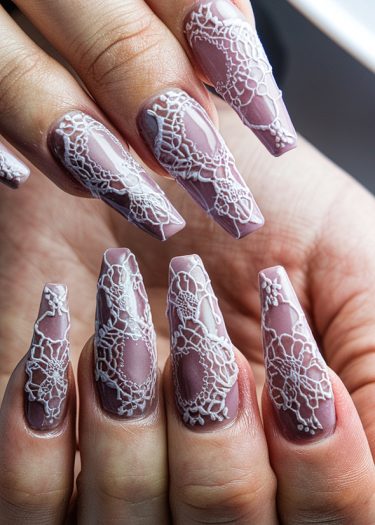 Elegant mauve stiletto nails with intricate white lace designs for sophisticated nail art.