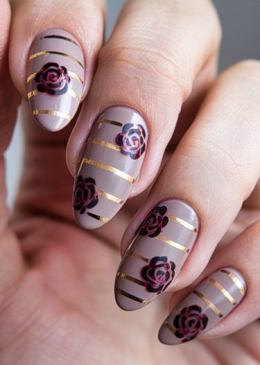 Elegant taupe nail art with black roses and gold stripes for a chic, sophisticated look.