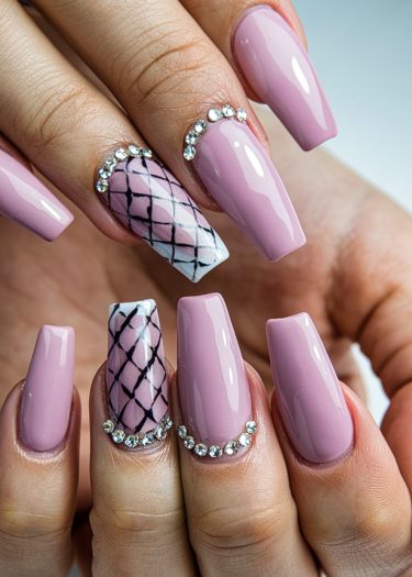 Elegant mauve nails with intricate designs and rhinestones for a glamorous manicure look.