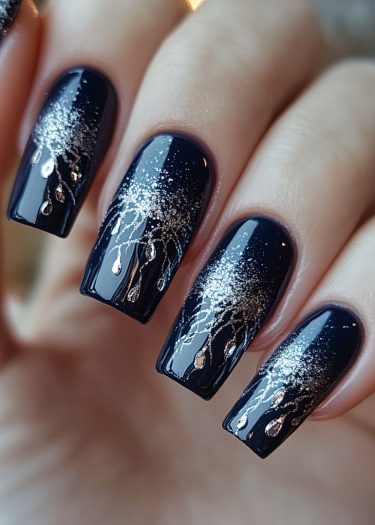 Elegant navy blue nails with intricate silver designs and glitter for a sophisticated look.