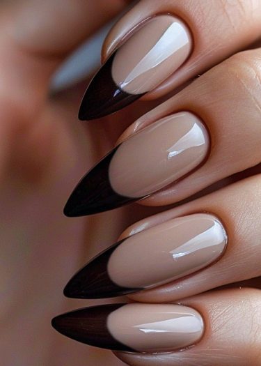 Elegant almond-shaped manicure with glossy nude base and dark brown French tips.