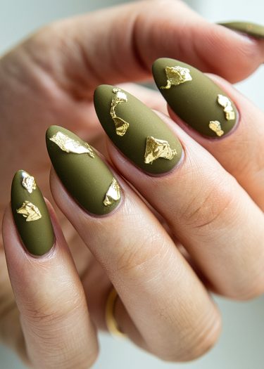 Elegant olive green manicure with gold foil accents on almond-shaped nails.